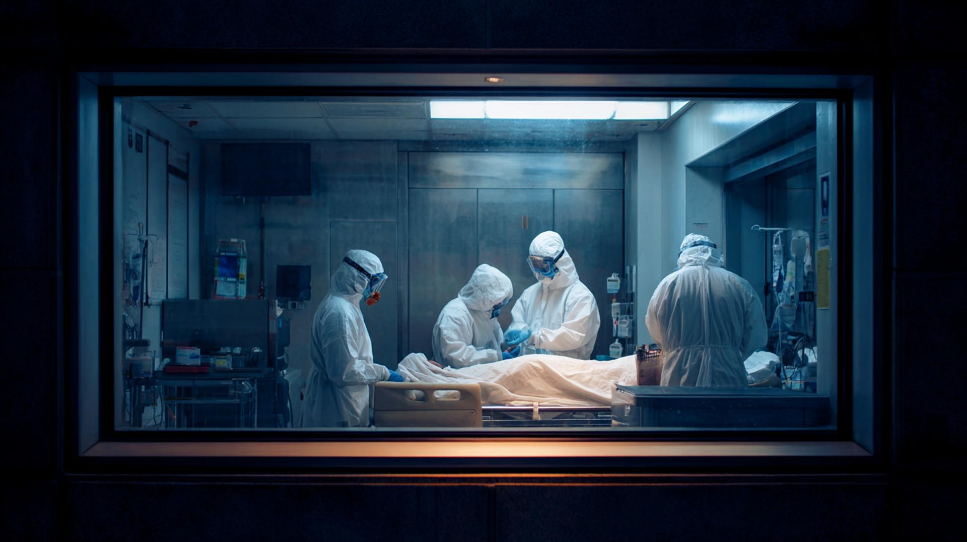 wo healthcare professionals in full PAPR protective gear practice infection control with a patient in an isolation room, a critical component of the Bioterrorism Preparedness CE Nursing course.